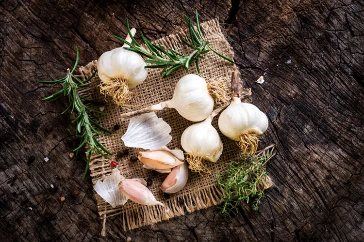 Garlic cloves with olive oil — garlic infused oil is low FODMAP and safe for IBS