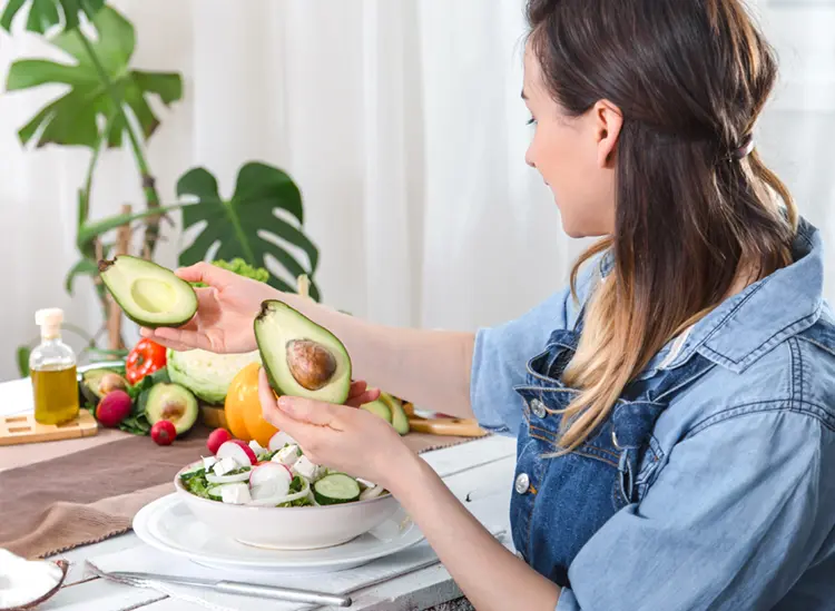 A ketogenic diet plate with salmon, eggs, avocado and green vegetables